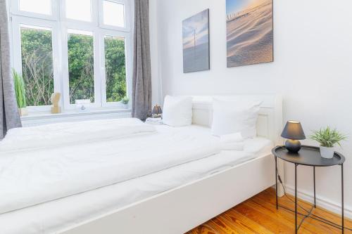 uma cama branca num quarto com uma janela em Koje Marina em Flensburg