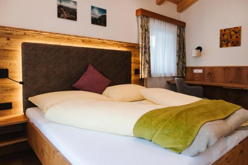 a bedroom with a large bed with white sheets at Bauernhof Haufhof Apartments, Haus im Ennstal bei Schladming in Haus im Ennstal