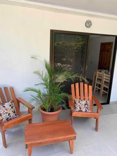 un porche con 2 sillas y una maceta en Calma Place, en Carrillo