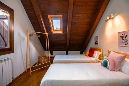 2 Betten in einem Zimmer mit Dachgeschoss in der Unterkunft Las Vistas de Peña Blanca in Piedrafita de Jaca