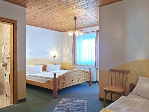 a bedroom with a large bed and a chair at Landhaus Christoph in Heiligenblut