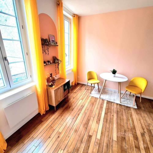 une chambre avec une table et deux chaises jaunes dans l'établissement Alba - terrasse, local à vélos et parking au centre historique, à Tonnerre