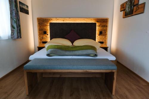 a bedroom with a bed with a wooden headboard at Apartments Haufhof , Haus im Ennstal bei Schladming in Haus im Ennstal
