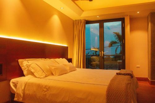 a bedroom with a bed and a large window at Hotel de Turistas Iquitos in Iquitos