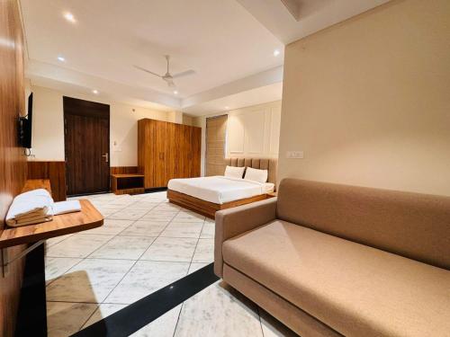 um quarto de hotel com uma cama e um sofá em Hotel Saaj Mansion em Jaipur