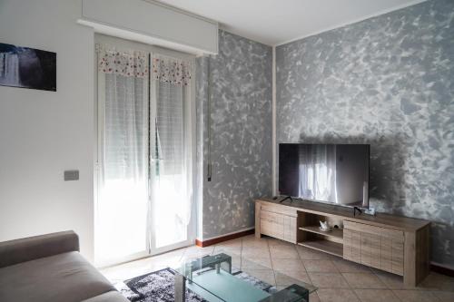 sala de estar con sofá y TV de pantalla plana en A Home away From Home By Alex Appartamento Malpensa Prestige Residence en Busto Arsizio
