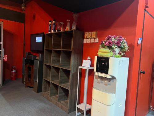 a room with a refrigerator and a tv and a shelf at Hanna homestay studio in Alor Setar