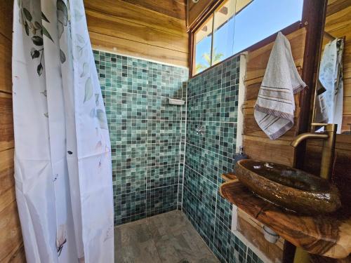 y baño con lavabo y ducha. en Natyva House en Guachaca