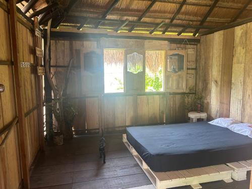 um quarto com uma cama num quarto de madeira em Punta Arena EcoHostal & EcoFit - Your Eco-Friendly Oasis 02 em Playa Punta Arena