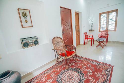 sala de estar con sillas y radio en la pared en Paddy N Pond Tree house Villa 2R, en Angamaly