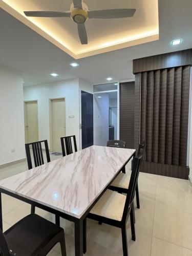 a dining room table with chairs and a ceiling fan at Sandakan IJM condo full-equipped homestay in Sandakan