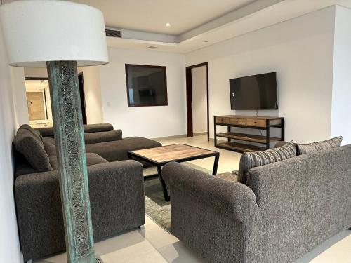 uma sala de estar com 2 sofás e uma televisão de ecrã plano em 1 Constitution Avenue by Goldfinch em Islamabad