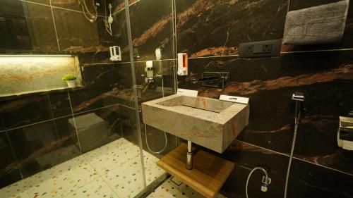 a bathroom with a sink and a glass wall at PANORAMIC PARADISE in Alwar