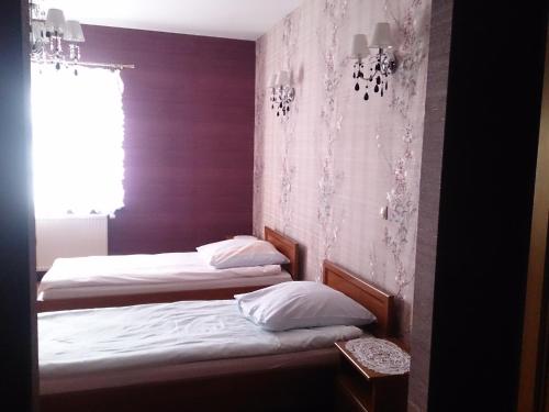 two twin beds in a room with a window at Mazurski Dwór in Olecko