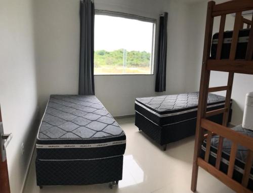 - 2 lits dans une chambre avec fenêtre dans l'établissement Faith Home 3, à Arraial do Cabo