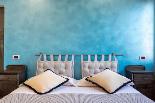Un dormitorio con una pared azul y una cama con almohadas en Stylish Apartment Rome, en Roma