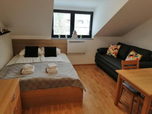 ein Schlafzimmer mit einem Bett und einem Sofa in der Unterkunft Apartma Happy in Kranjska Gora