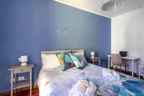 een blauwe slaapkamer met een bed met handdoeken erop bij Station & Center - Self Check-in & Access in Como