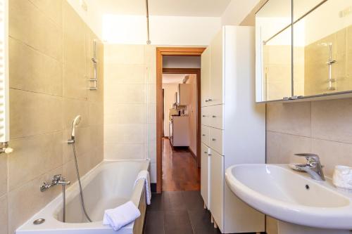 een badkamer met een wit bad en een wastafel bij Station & Center - Self Check-in & Access in Como