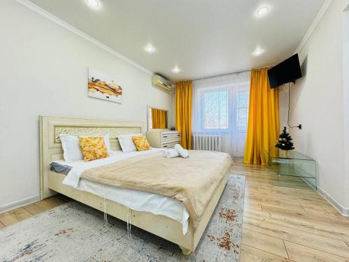 a bedroom with a large bed with yellow curtains at Infinity Estate MEGA Park in Almaty