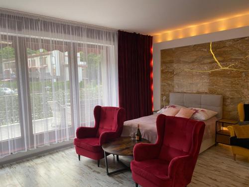 a bedroom with a bed and two chairs and a table at Apartament z tarasem in Wisełka