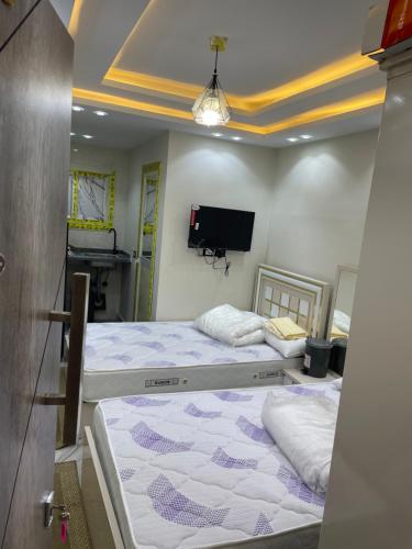 Duas camas num quarto com televisão em استديوهات فندقية em Cidade 6 de Outubro