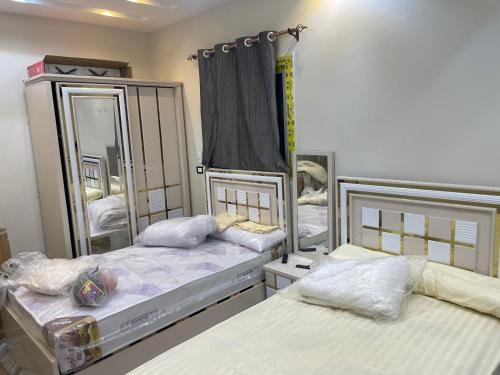 een slaapkamer met 2 bedden en een spiegel bij استديوهات فندقية in Zes oktober (stad)