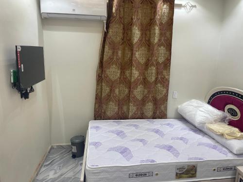 een kleine kamer met een bed en een gordijn bij استديوهات فندقية in Zes oktober (stad)