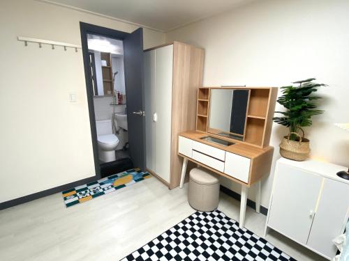 um quarto com uma secretária, uma televisão e uma casa de banho em white room private bathroom Red Panda Guesthouse em Seul