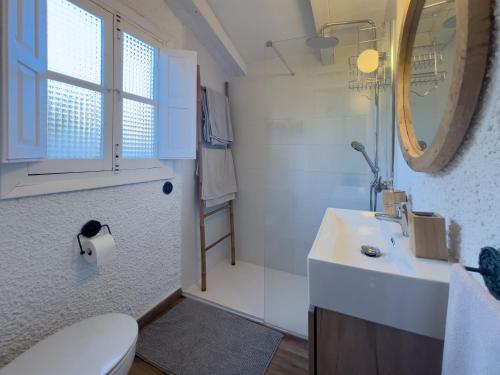 uma casa de banho com um lavatório, um WC e um espelho. em La cabaña del Burguillo em El Barraco