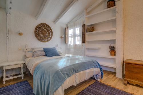 a bedroom with a bed in a room with shelves at La cabaña del Burguillo in El Barraco