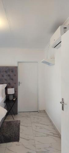 a white room with a door and a bed at Walvis Bay Staycation in Walvis Bay