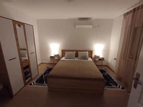 a bedroom with a large bed and two lamps at Kućica LaMa in Mali Mokri Lug