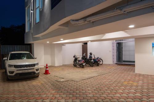 a car parked in front of a building with motorcycles at AAFIYA LAKEVIEW APARTMENTS in Coimbatore