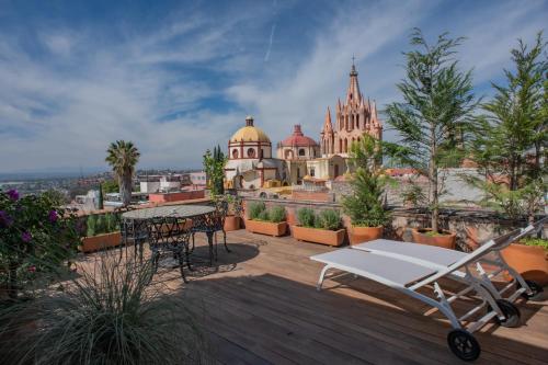 a balcony with a table and chairs and a building at Suite de Lujo con Terraza Panorámica in San Miguel de Allende