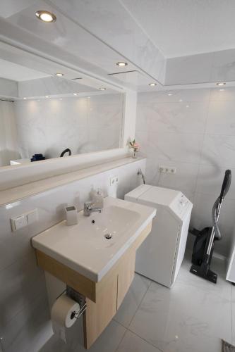 a white bathroom with a sink and a toilet at Appartment mit Parkplatz in Würzburg