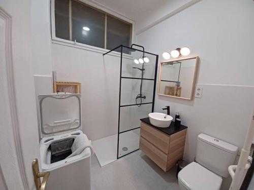 Baño blanco con lavabo y aseo en Hero's Square Apartment en Budapest