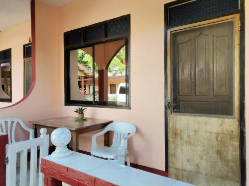 a room with a door and a table and chairs at JBR Tourist Inn - Port Barton in Itaytay