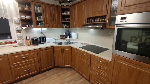 a kitchen with wooden cabinets and a sink and a microwave at Holiday Home Moldava in Moldava