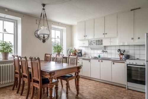 kuchnia z drewnianym stołem i krzesłami w obiekcie Vita Huset på Österlen w mieście Gärsnäs