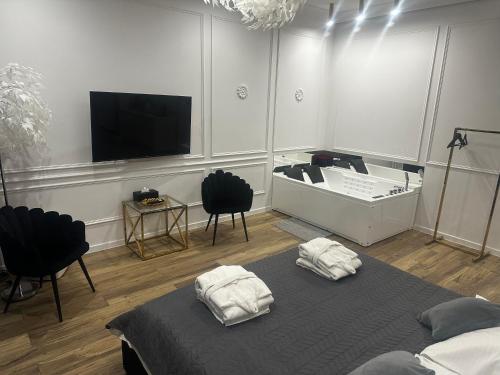 Zimmer mit einem Bett und einem Flachbild-TV in der Unterkunft Apartament Shine Prywatne Jacuzzi Starowiślna Kraków in Krakau