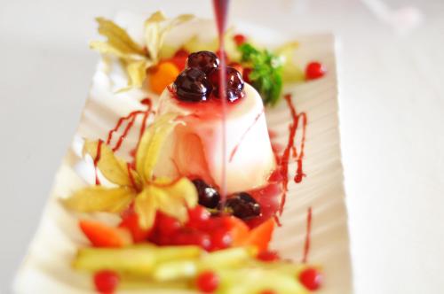 a plate of food with fruit and sauce at Grand Hotel Palladium Santa Eulalia del Río in Santa Eularia des Riu