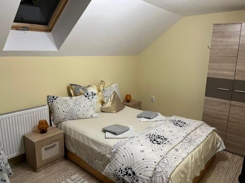 a bedroom with a bed with white sheets and pillows at Casa Ana Maria in Cisnădie