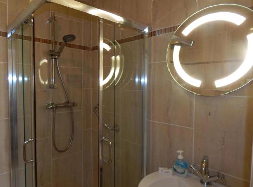 a bathroom with a shower and a sink and a mirror at Glencove in Ennis