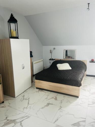 - une chambre avec un lit et un réfrigérateur dans l'établissement Logement studio, à Quintin