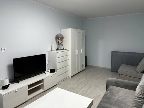 sala de estar blanca con TV de pantalla plana en Tallinn's Prime Spot: Pae 49 - Near Airport, Concerts & Shops en Tallin