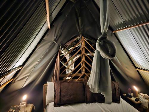 um quarto com uma cama numa tenda em Glamping El Árbol en la Casa em San Antonio del Tequendama