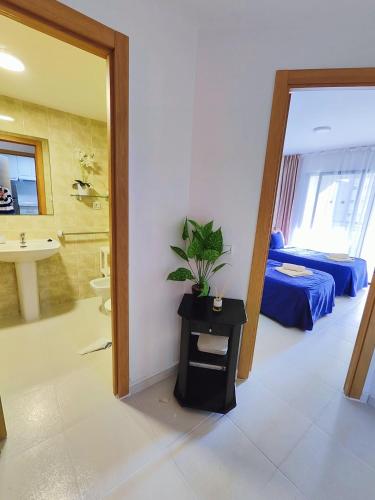 Pokój z łazienką z łóżkiem i umywalką w obiekcie Playa Levante Lux Mar w mieście Benidorm
