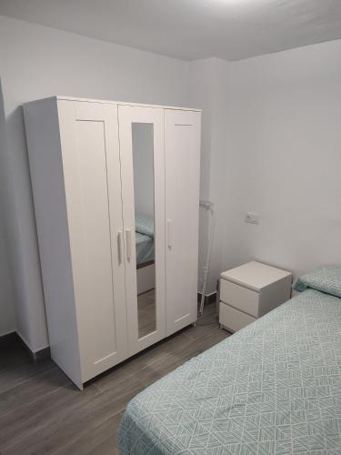 a bedroom with a white cabinet and a bed at Playgarza relax in Telde