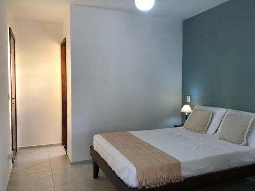 a bedroom with a bed and a blue wall at Canto Santo in Itapoa